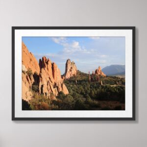 A high-resolution photograph of the red rock formations at Garden of the Gods in Colorado Springs, Colorado, with a vibrant blue sky and green forested foreground.