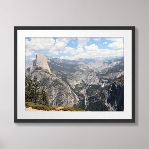 A breathtaking view of Half Dome with Vernal and Nevada Falls cascading in the distance, surrounded by lush forests and granite cliffs in Yosemite National Park.