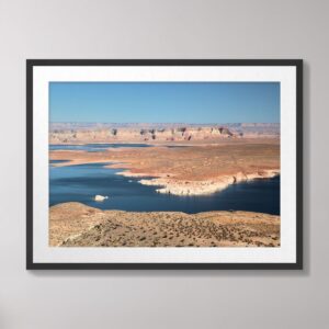 A stunning view of Wahweap Bay at Lake Powell with deep blue water and red rock formations under a clear blue sky in Glen Canyon National Recreation Area, Page, Arizona.