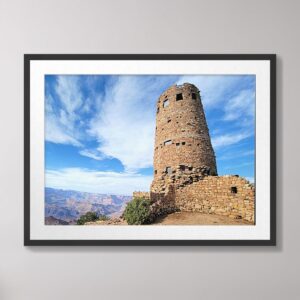 A stunning photograph of the historic Watchtower at Grand Canyon National Park, perched on the South Rim under a vivid blue sky.