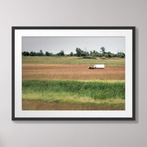 Photograph of a covered wagon on the prairie at the Laura Ingalls Wilder Homestead in De Smet, South Dakota, with tall grass and a clear sky in the background.