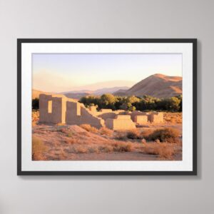 Fort Churchill ruins at sunset in Silver Springs, Nevada, surrounded by desert vegetation and distant mountains under a warm golden sky.