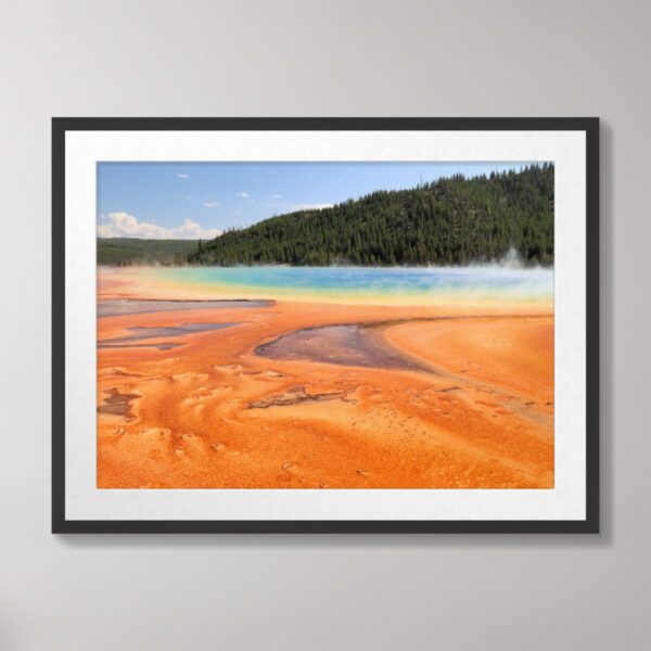 Grand Prismatic Spring at Yellowstone National Park with vivid orange, blue, and green colors surrounded by forest.