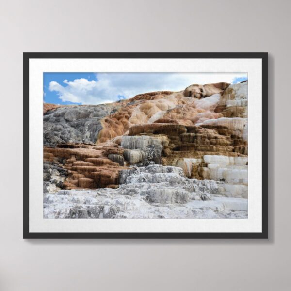 Mammoth Hot Springs at Yellowstone National Park showcasing colorful terraces under a blue sky.