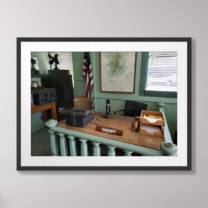 Photograph of a vintage sheriff’s office inspired by Andy Griffith’s Mayberry, featuring a typewriter, microphone, American flag, and map, taken in Mount Airy, North Carolina.