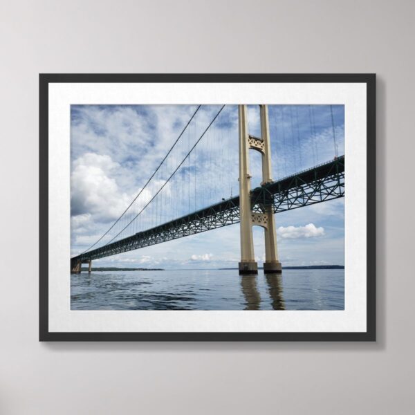 A striking view of the Mighty Mac Bridge near Mackinac Island, showcasing its towering architecture against a serene sky and water reflection.