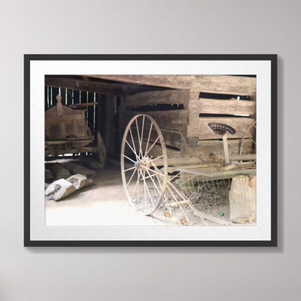 A rustic farm scene in Cades Cove, Great Smoky Mountains, featuring antique farm equipment and a wooden barn.