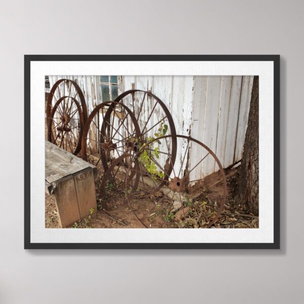 Rustic old wagon wheels leaning against a weathered wooden building at Buffalo Gap, Texas.