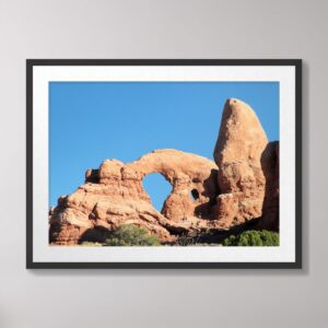 Photograph of Turret Arch at Arches National Park in Moab, Utah, featuring a clear blue sky and stunning rock formations.