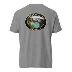 Grey Comfort Colors 1717 heavyweight T-shirt featuring Arch Rock on Mackinac Island, Michigan, with a scenic lake view framed by natural rock formations in an oval design.