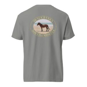 Grey Comfort Colors 1717 heavyweight T-shirt featuring a graphic of a wild horse on the sandy beaches of the Outer Banks, North Carolina, with the ocean in the background, in an oval design.