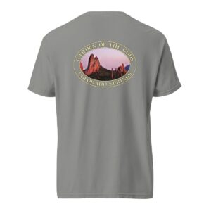 Grey Comfort Colors 1717 heavyweight T-shirt featuring a Sunset at Garden of the Gods in Colorado Springs graphic with red rock formations and a pink sky in an oval design.