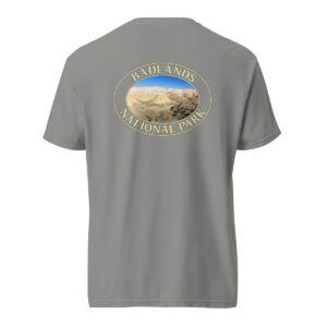 Grey Comfort Colors heavyweight T-shirt featuring a scenic Yellow Mounds design at Badlands National Park, framed in an oval border.