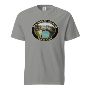 Grey Comfort Colors 1717 heavyweight T-shirt featuring Arch Rock on Mackinac Island, Michigan, with a scenic lake view framed by natural rock formations in an oval design.