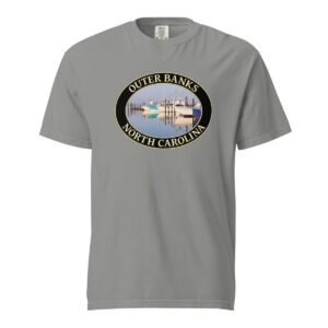 Grey Comfort Colors 1717 heavyweight T-shirt featuring a fishing boats graphic at Oregon Inlet, Outer Banks, North Carolina, with calm water reflections and a clear sky in an oval design.