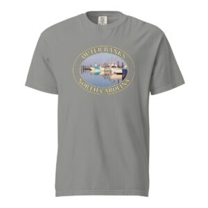 Grey Comfort Colors 1717 heavyweight T-shirt featuring a fishing boats graphic at Oregon Inlet, Outer Banks, North Carolina, with calm water reflections and a clear sky in an oval design.