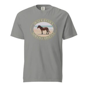 Grey Comfort Colors 1717 heavyweight T-shirt featuring a graphic of a wild horse on the sandy beaches of the Outer Banks, North Carolina, with the ocean in the background, in an oval design.