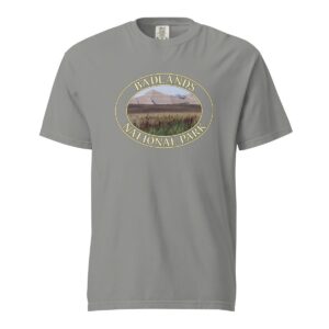 Grey Comfort Colors 1717 heavyweight T-shirt featuring a scenic graphic of reeds at Badlands National Park, framed in an oval design.