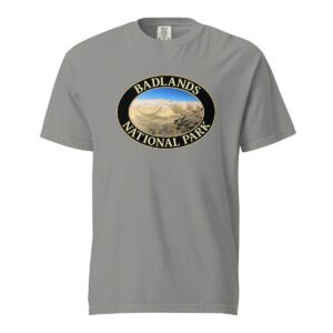 Grey Comfort Colors heavyweight T-shirt featuring a scenic Yellow Mounds design at Badlands National Park, framed in an oval border.