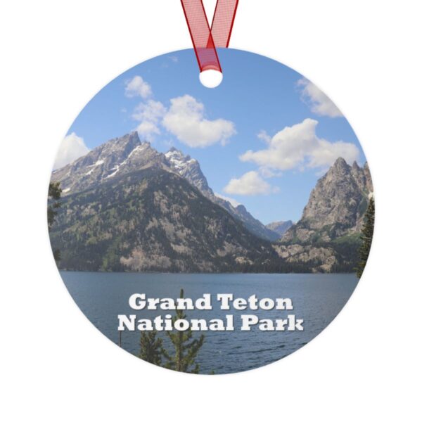 A 3.5-inch aluminum ornament featuring a serene view of Jenny Lake with towering mountain peaks at Grand Teton National Park. Includes a red ribbon for hanging.