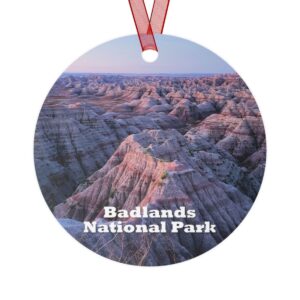 Badlands National Park ornament featuring a vibrant sunrise over the rugged terrain, 3.5-inch aluminum design with red ribbon.