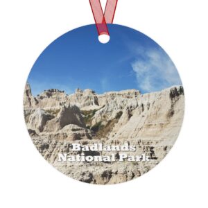 Badlands National Park ornament featuring rugged rock formations under a bright blue sky, 3.5-inch aluminum design with red ribbon.