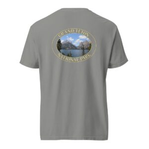 Grey Comfort Colors heavyweight T-shirt featuring a scenic image of Jenny Lake at Grand Teton National Park, framed in an oval border.